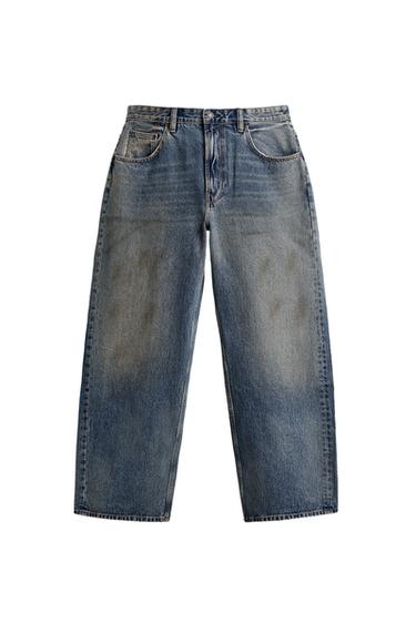 Front view of light blue baggy fit jeans, vintage effect, five pockets, front zip and button fastening.