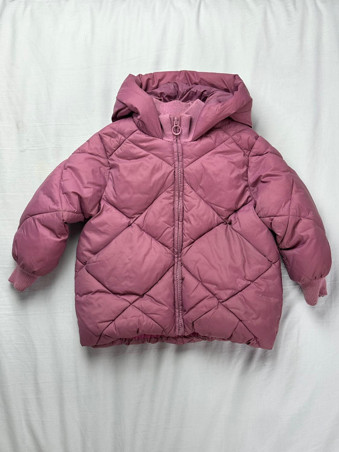 Quilted pink jacket with a hood, a diamond pattern, and ribbed cuffs on a white background.