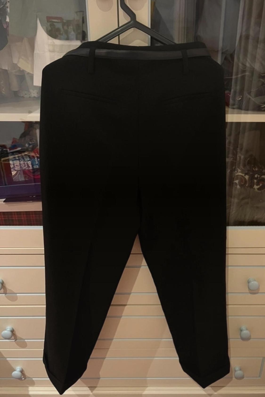 Rear view of black trousers with back pockets.