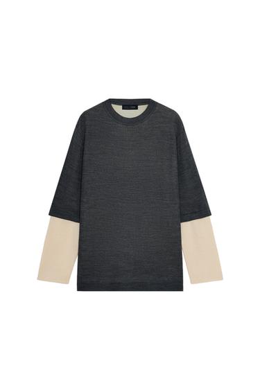 Front view of a grey marl knitted jumper with a round neck and contrasting beige long sleeves.