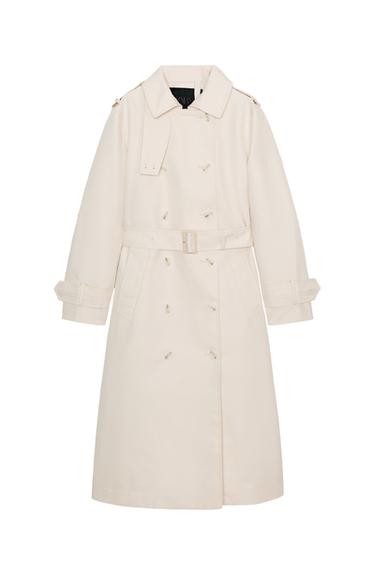 Front view of a light beige trench coat with a lapel collar, long sleeves, front pockets and a buckle belt. Double-breasted button fastening.