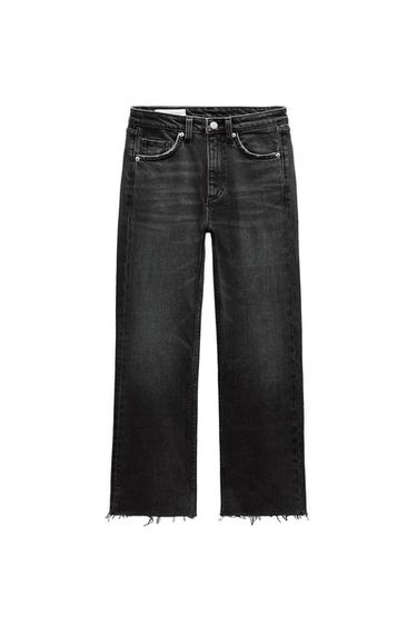 Front view of black jeans with front pockets and frayed hem.