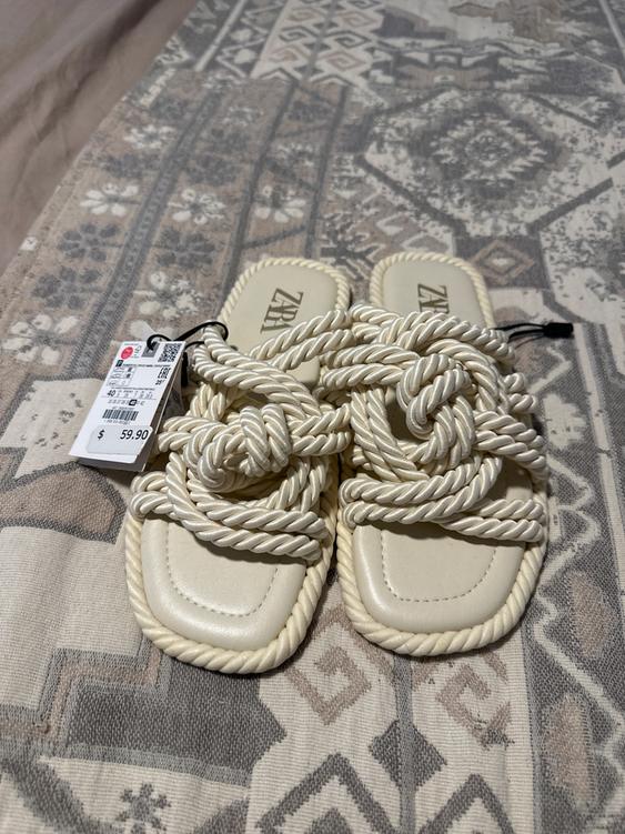 Beige rope sandals with a $59.90 price tag on a fabric with a geometric design in neutral tones.