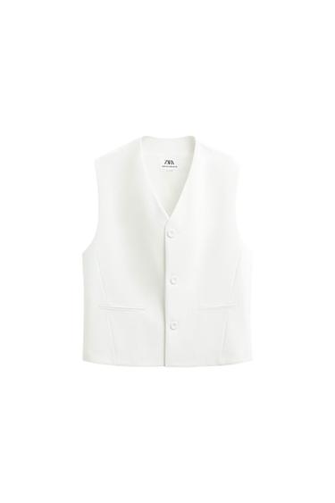 White sleeveless waistcoat with front buttons and pockets, on a white background. Visible inner label with "ZARA" text.
