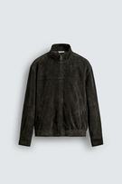 Front view of a dark bottle green bomber jacket with a raised collar, front zip, side pockets, and elasticated hem.