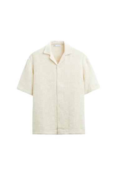 Relaxed-fit short-sleeve shirt in cream with texture and a lapel collar. Button closure against a white background. Interior label with ZARA text.