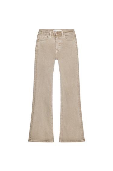 Front view of beige flared trousers with front pockets.