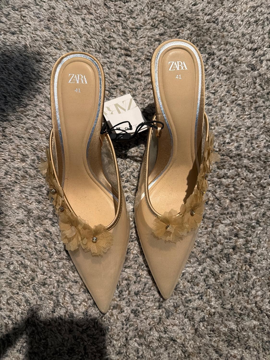 Beige high heels with decorative flowers and rhinestones, Zara brand, size 41, on a gray carpet.