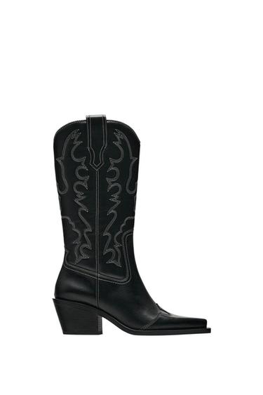 Black mid-heel boot with white embroidered design on the side, cowboy style, white sole.