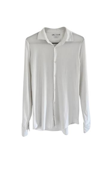 Front view of a long-sleeved white button-up shirt with a classic collar.