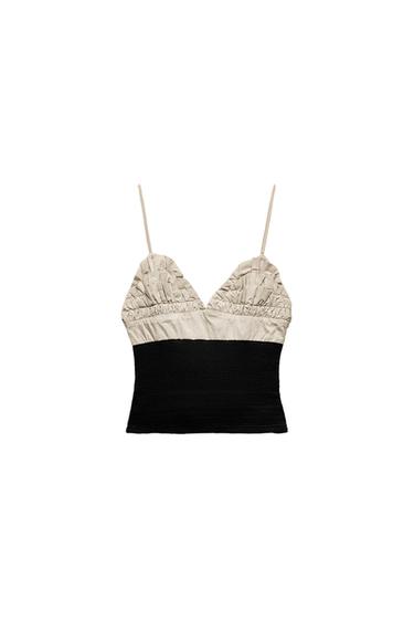Front view of a two-tone top with spaghetti straps and ruching at the bust.