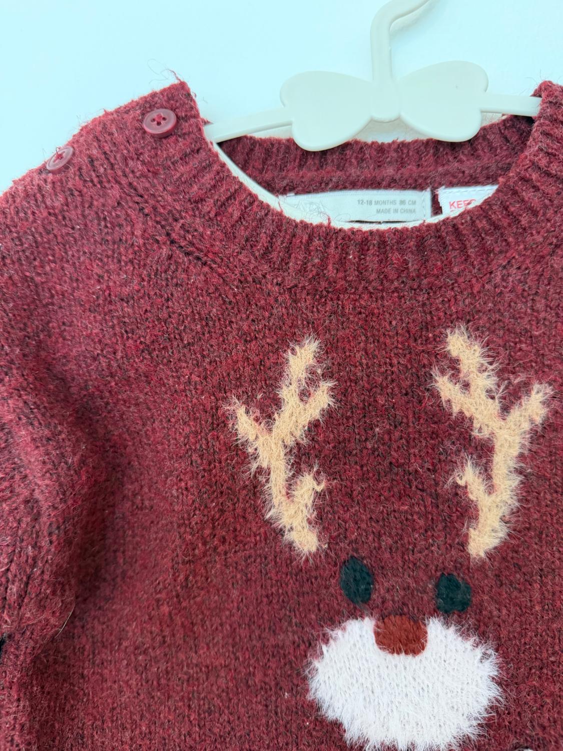 Maroon knitted jumper with reindeer face and white hanger buttons. Text: 12-18 MONTHS 86 CM MADE IN CHINA.