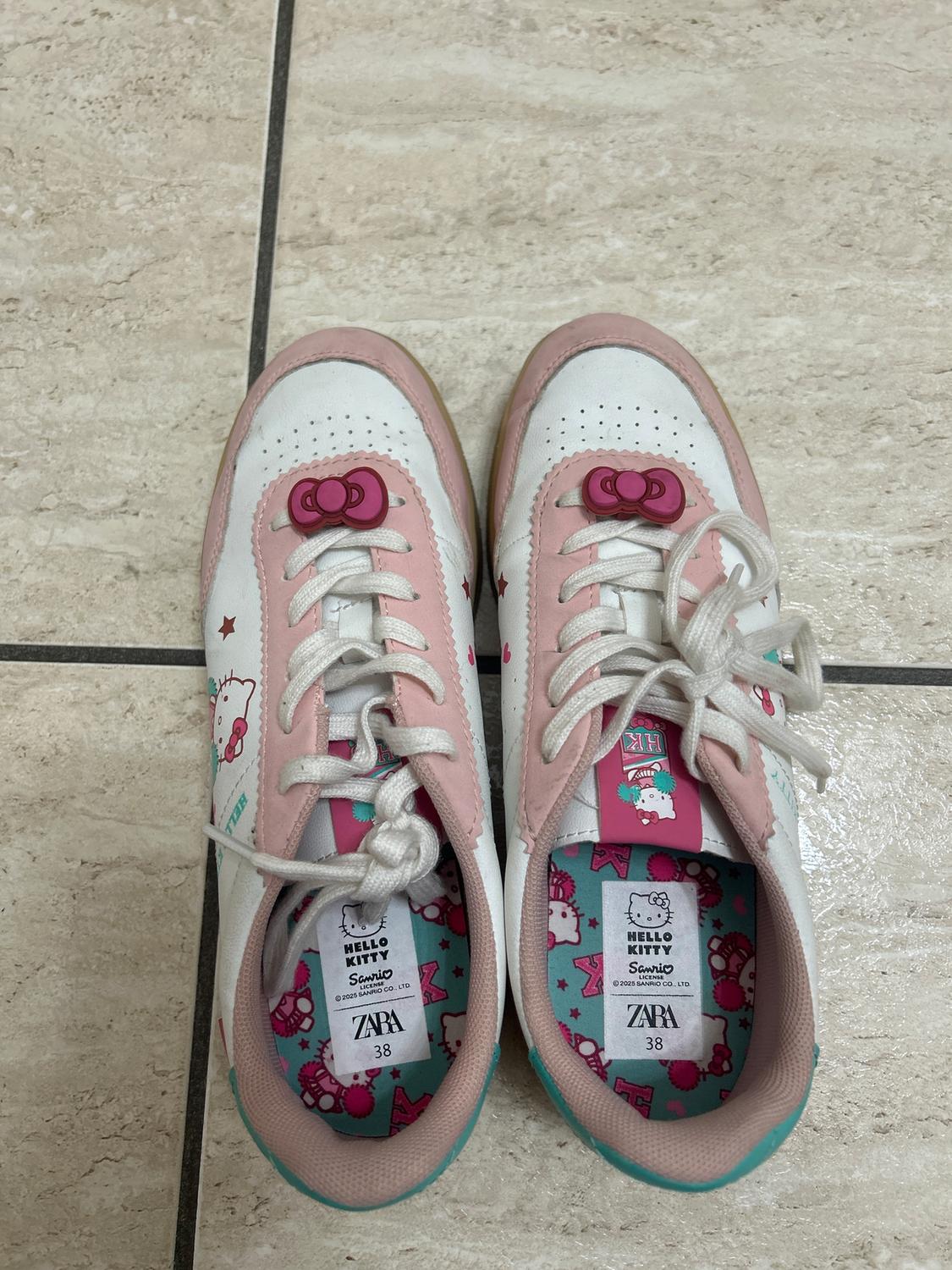 White and pink trainers with a Hello Kitty design, white laces, and a turquoise sole. Inside tag: "Hello Kitty Sanrio ZARA 38".