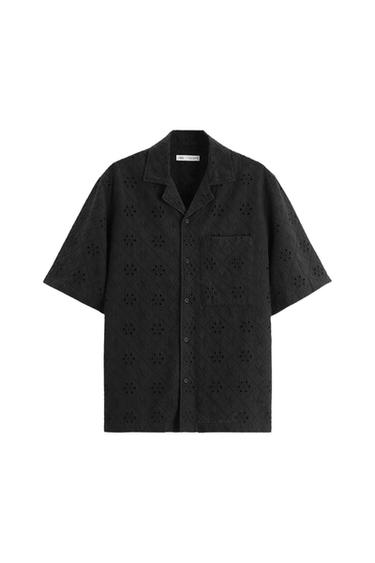 Front view of a black shirt with a perforated pattern and a chest pocket.