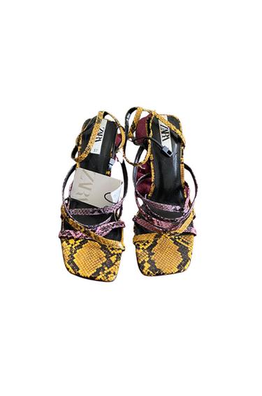 Front view of multi-coloured sandals with straps and snake print.