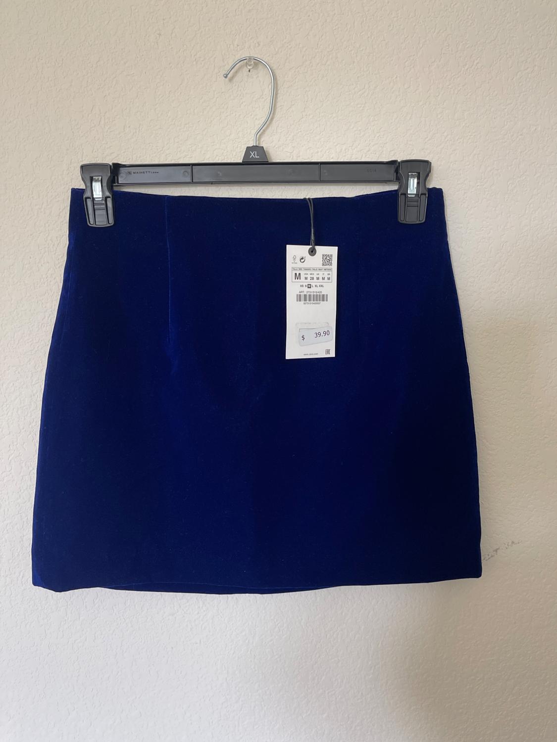 Blue skirt hanging on a black hanger with a price tag of 39.90. White background.