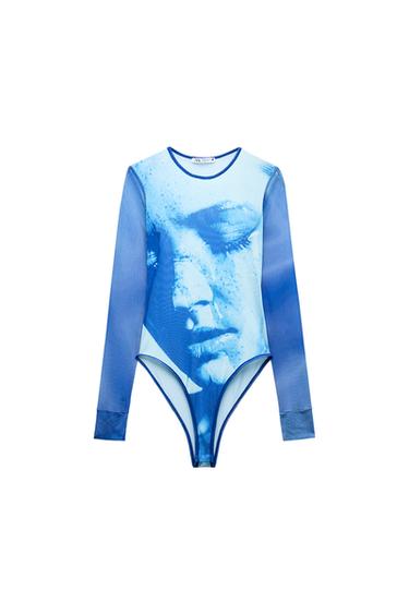 Front view of a blue bodysuit with a face print and long sleeves.