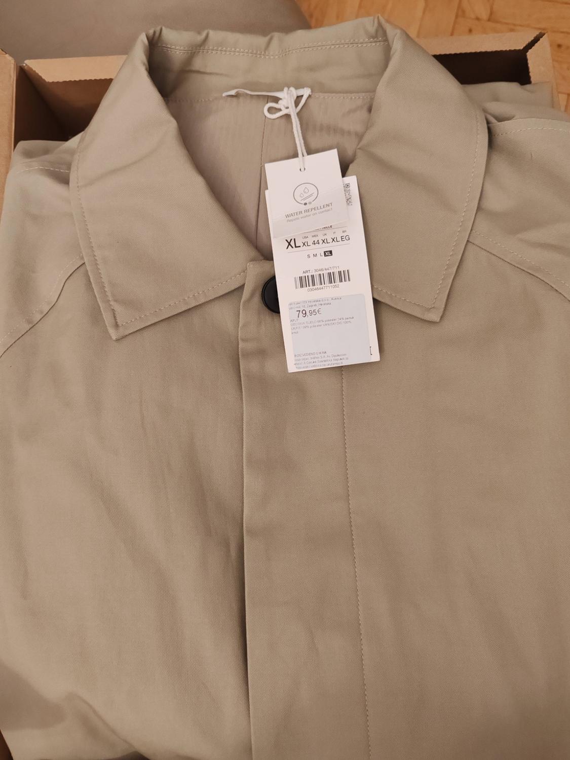 Beige jacket with a shirt collar, folded in a box. Visible label with the text WATER REPELLENT, XL, €79.95.