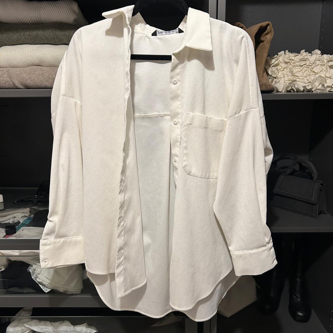 Front view of a white shirt with a left front pocket and long sleeves.