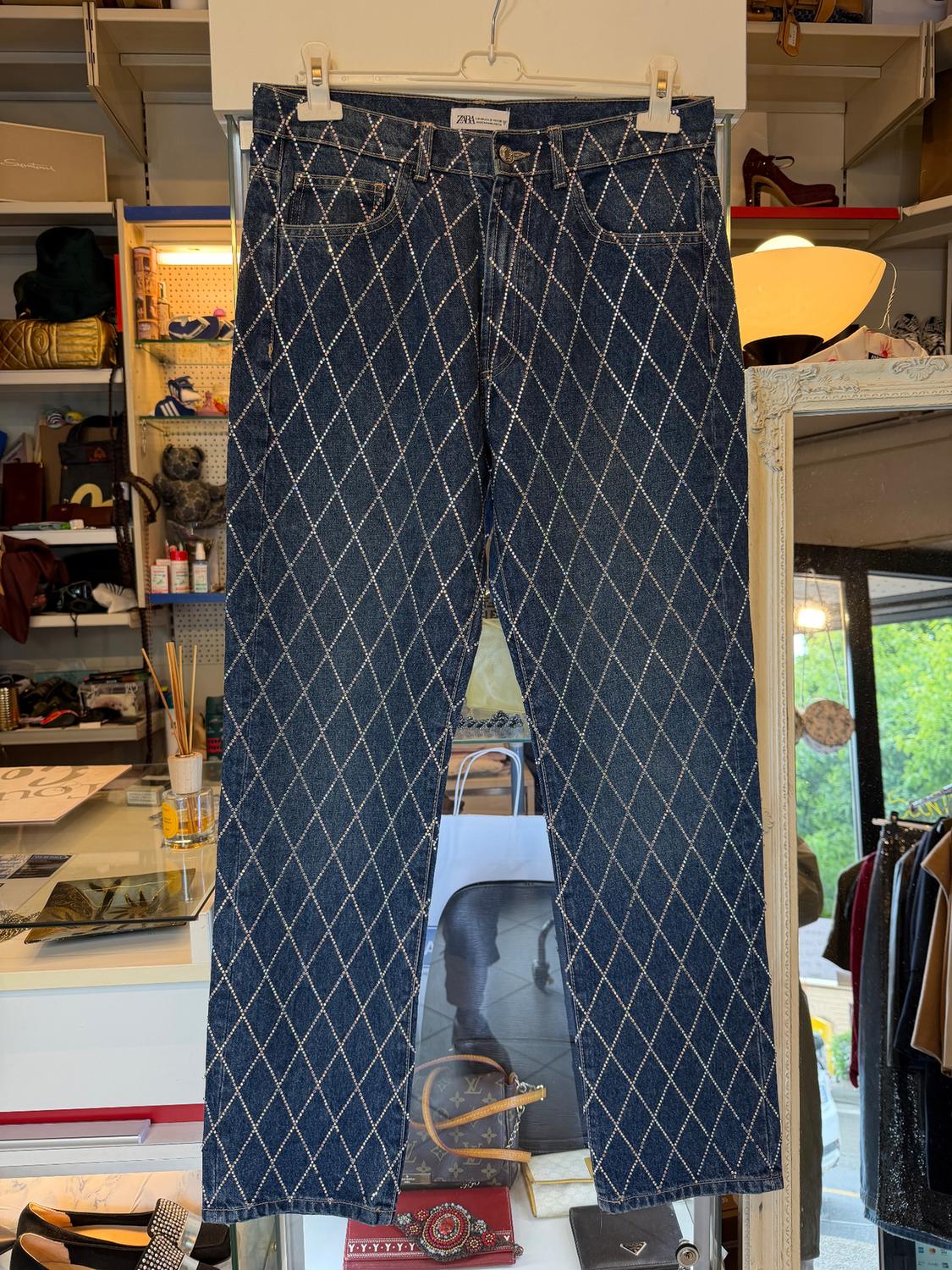 Jeans with a diamond pattern hanging in a shop, surrounded by accessories and clothes on shelves and hangers.