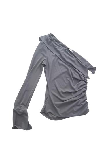 Gray long-sleeve blouse with an asymmetrical design and side ruching, on a white background.