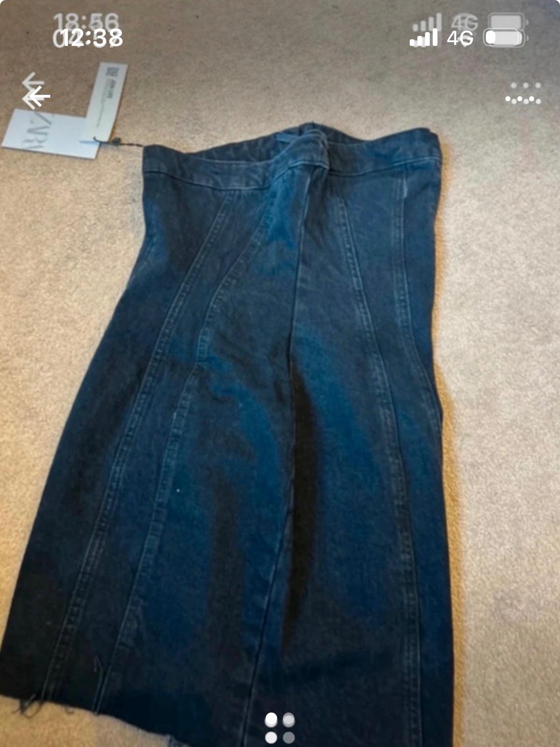 Dark blue denim maxi skirt on a beige rug, with a visible tag. Screen shows time and mobile signal.