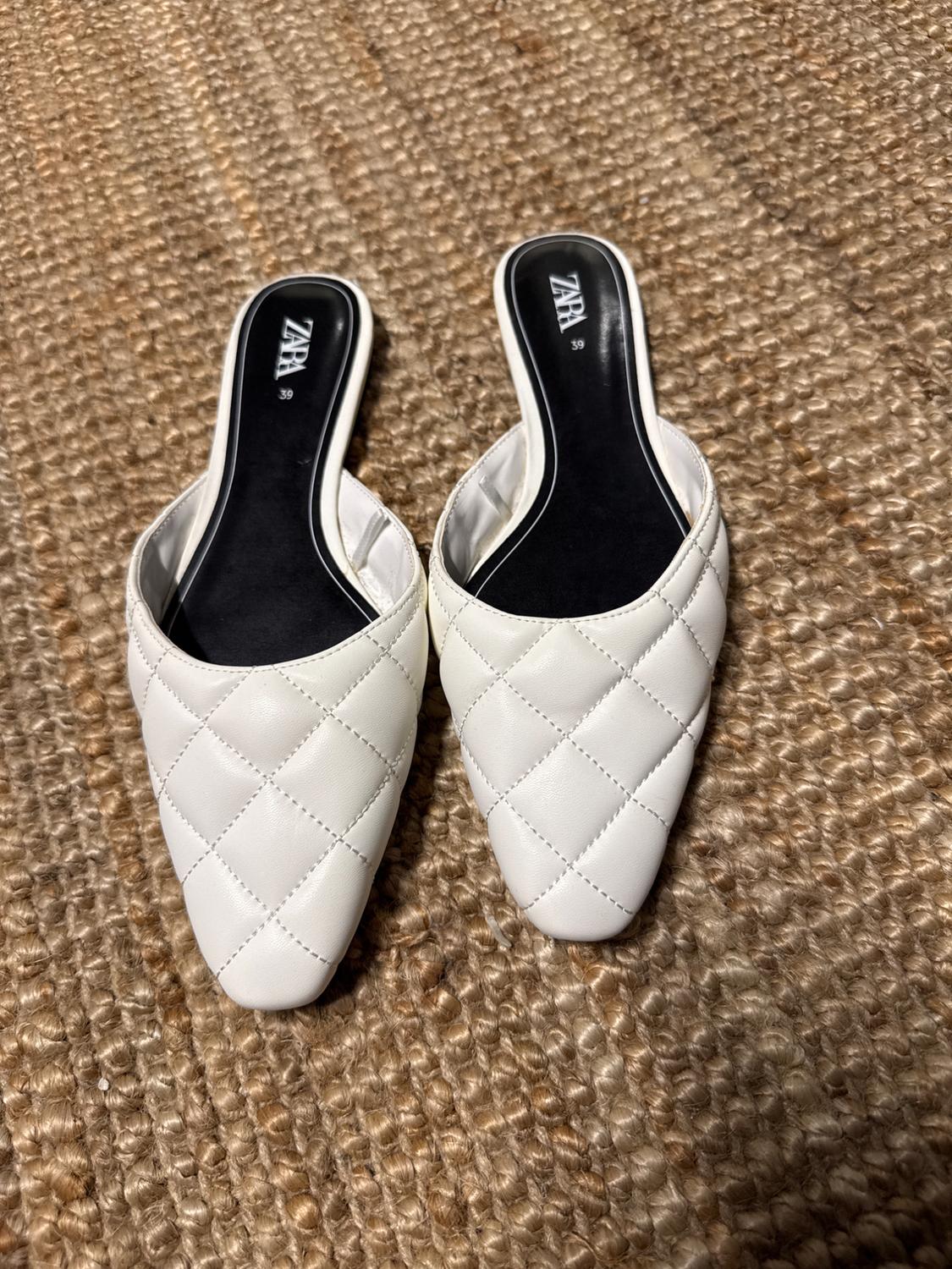 White shoes with quilted design and square toe on a jute rug. Black insole with "ZARA" logo and size 39 visible.