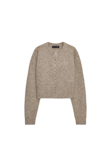 Front view of a toasted cropped jacket with a round neck, long sleeves and a front button fastening. Ribbed finishes.