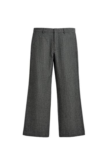 Front view of tailored grey trousers with a straight cut, belt loops, and a front fastening.