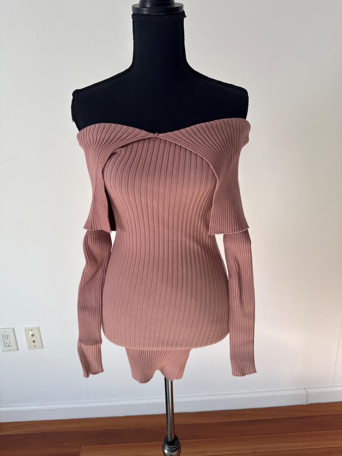 Front view of a pink ribbed jumper with an off-the-shoulder neckline and long sleeves.