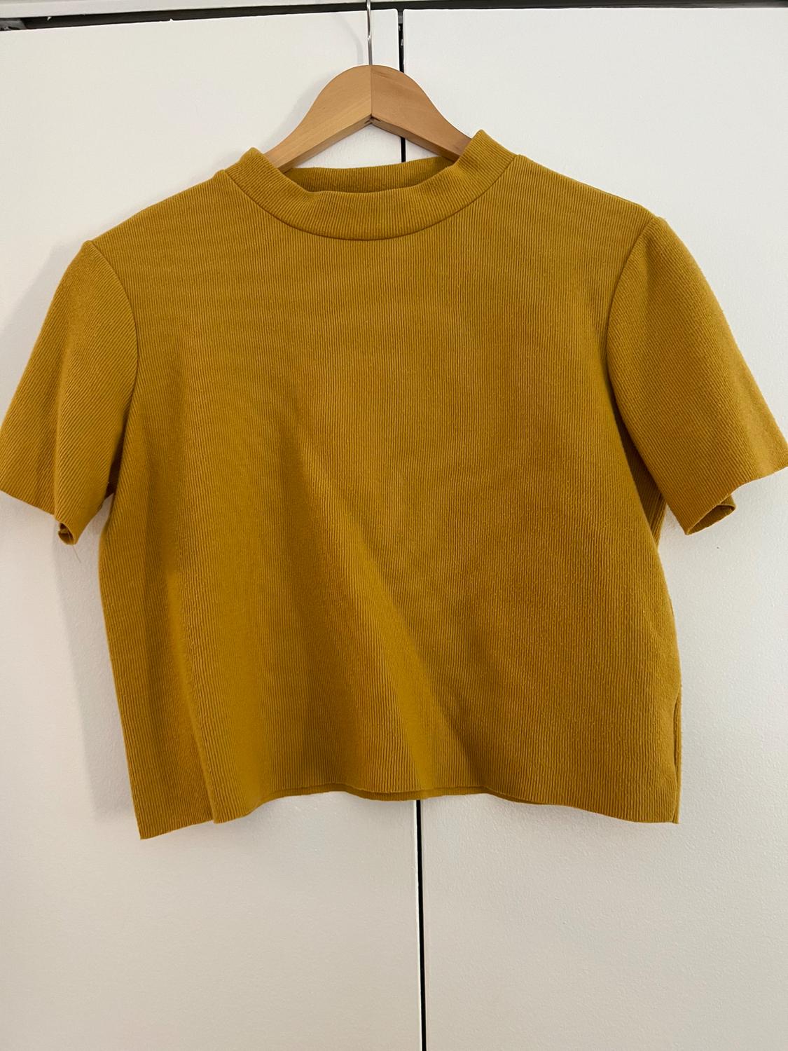 Front view of a yellow short-sleeved crew-neck t-shirt on a hanger.
