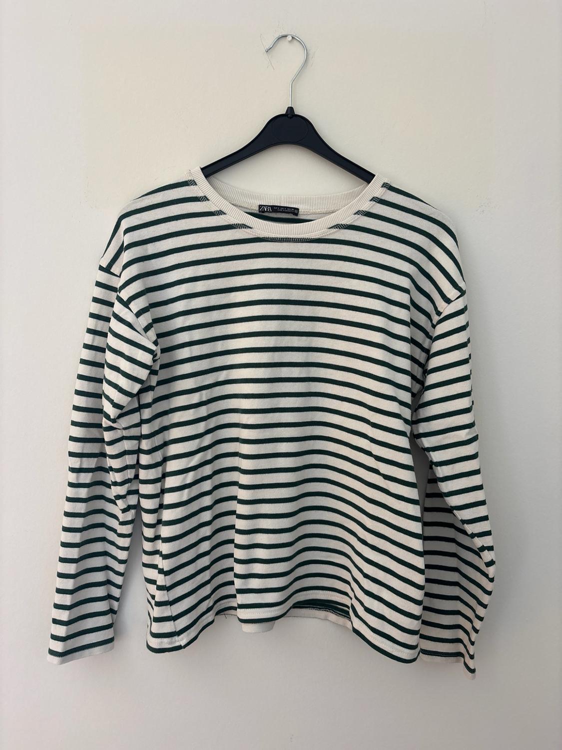 Long-sleeved horizontal striped T-shirt hanging on a black hanger against a white background. ZARA label.