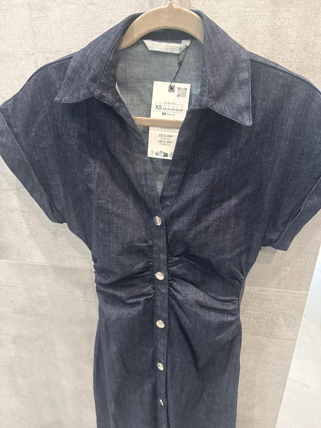 Dark blue denim dress with short sleeves, buttons, and ruching. Text: ZARA XS XS 24 XS XS EP US $59.90 UK £35.99.