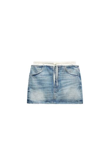 Light blue denim mini skirt with white elasticated waist and adjustable drawstring. Visible front pockets. White background.