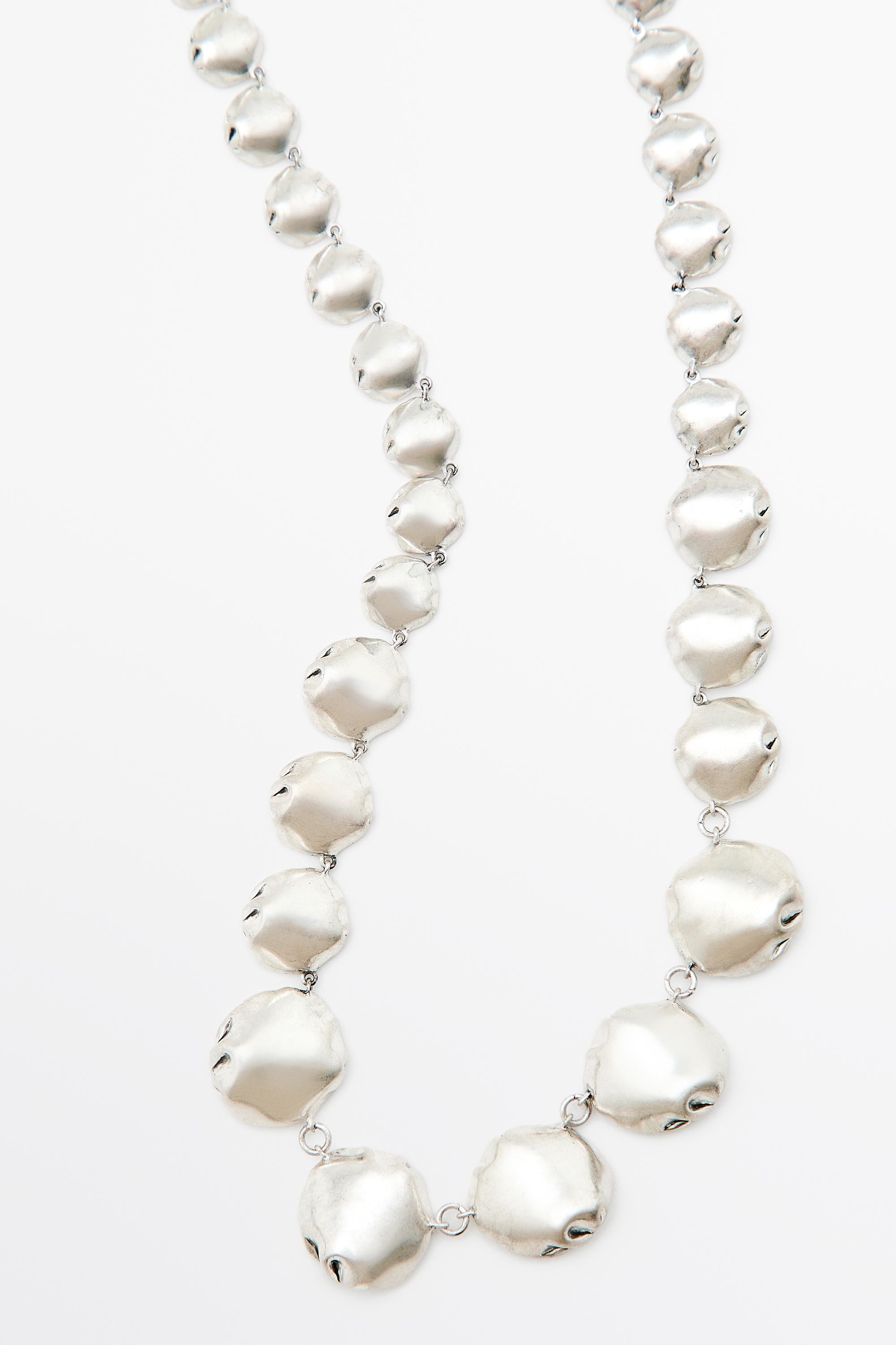 Collier long à pièces métalliques