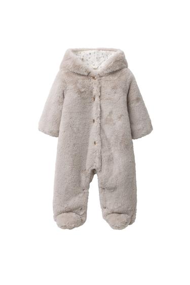 Front view of beige jumpsuit with hood and long sleeves, front button and snap closure on legs, visible floral lining.