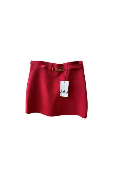 Red mini skirt with a decorative gold belt and a "ZARA" hangtag. White background.