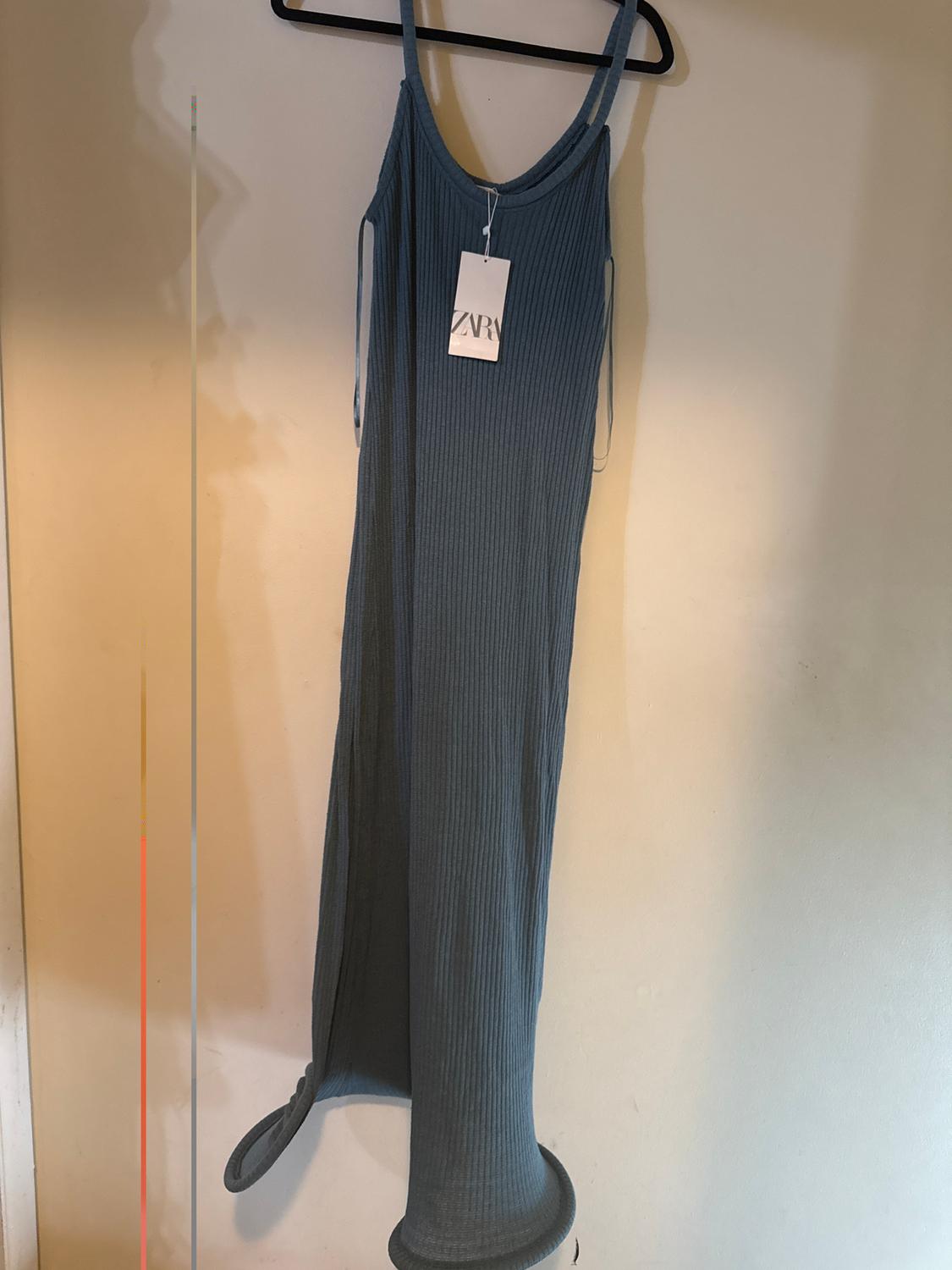 Blue spaghetti strap dress hanging on a black hanger, with a visible "ZARA" tag, against a white background.
