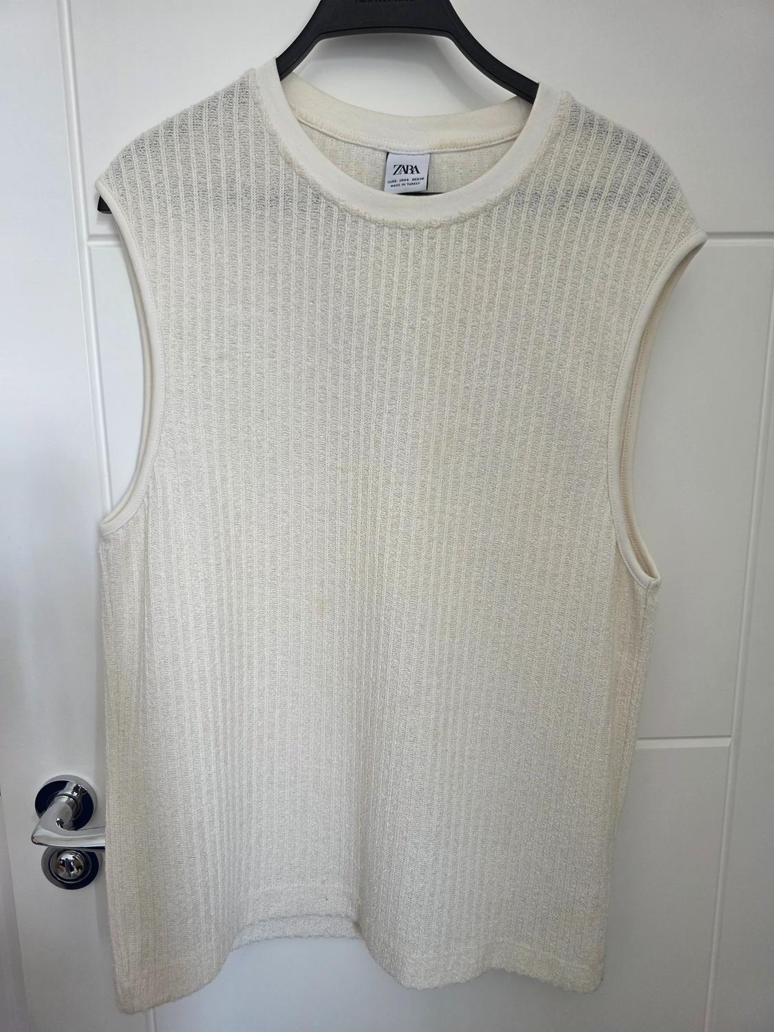 Cream ribbed sleeveless top on a black hanger against a white door. Label with text: ZARA EUR S USA S MEX 26 MADE IN TURKEY.