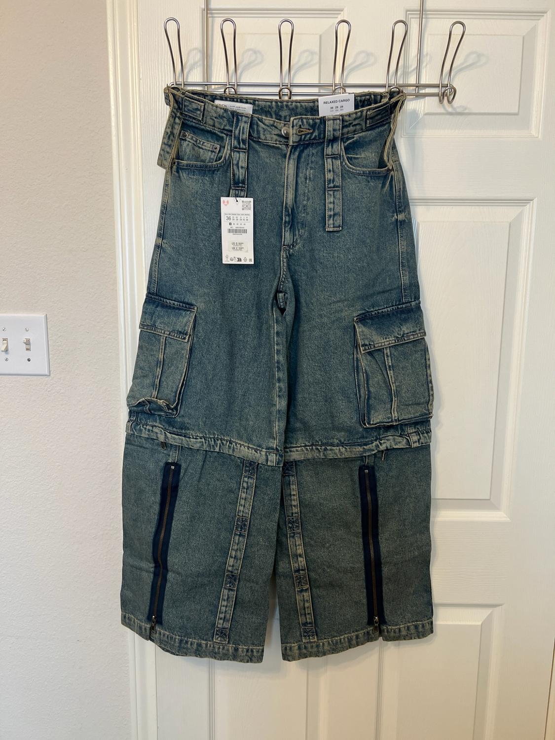 Blue denim hanging on a white door. It features cargo pockets, zips at the bottom and a label with the text RELAXED CARGO.
