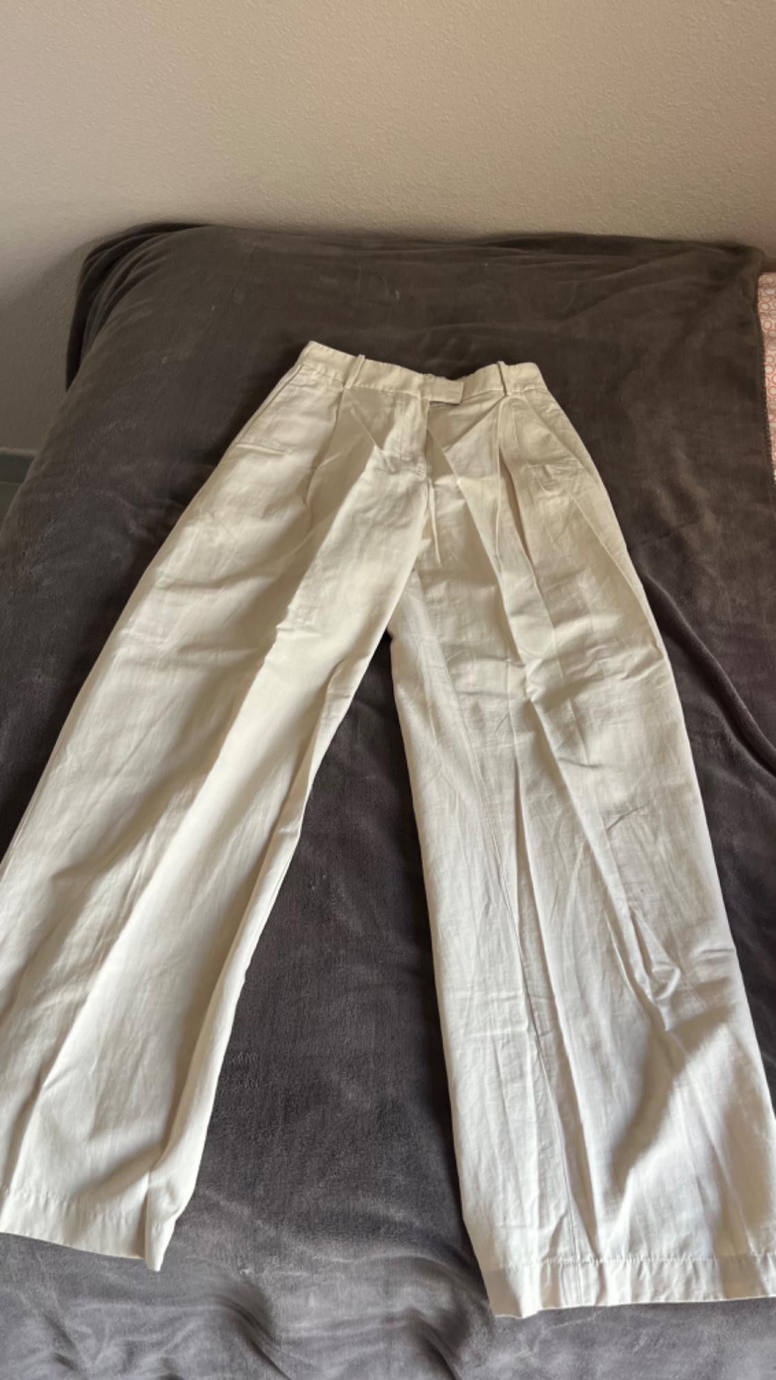 Μπροστινή όψη λευκού παντελονιού με πιέτες και πλαϊνές τσέπες.