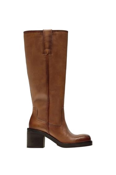 Brown leather knee-high boot with a block heel, rounded toe and stitched detailing, on a white background.