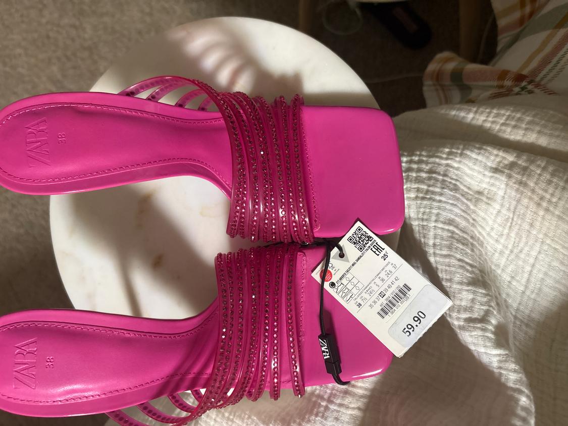 Fuchsia sandals with glittery straps on a white table. Visible price tag: 59.90. Brand and size: ZARA, 38.
