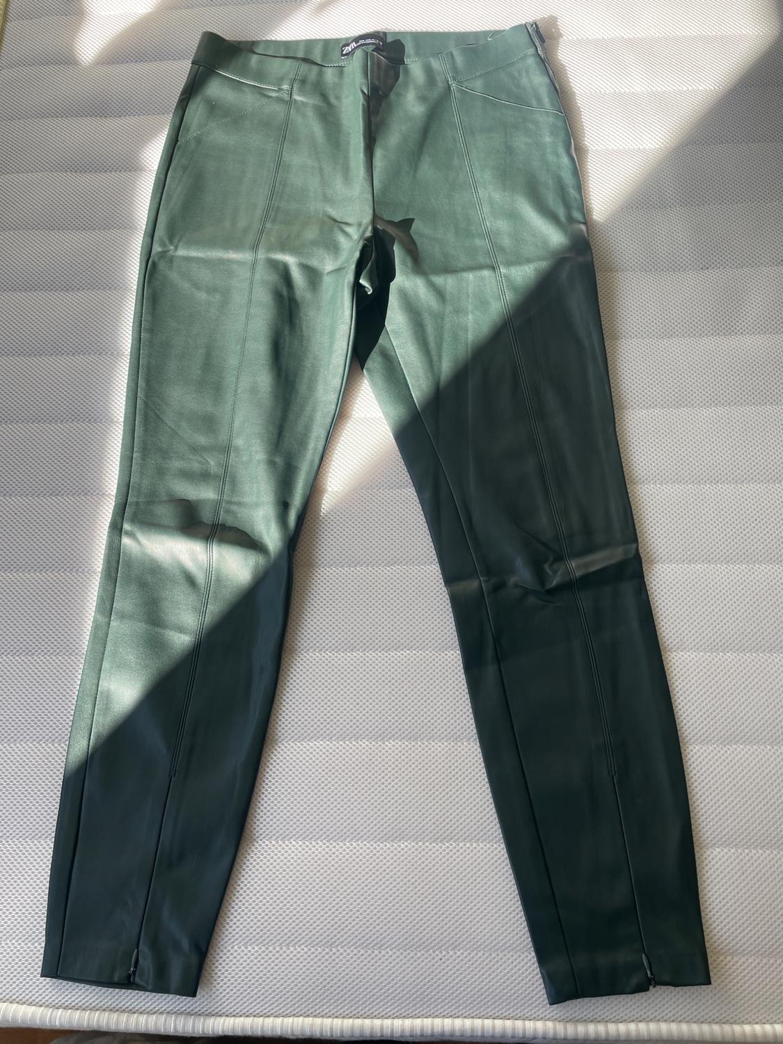 Front view of green trousers with side pockets and visible seams.