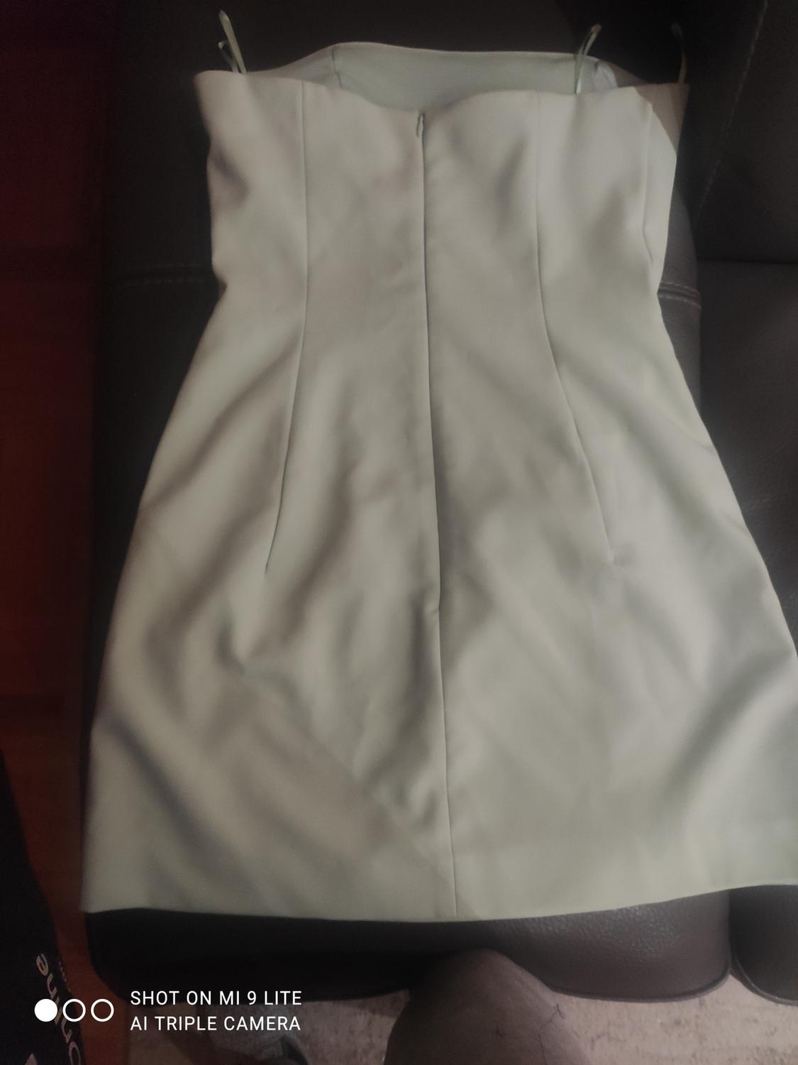 Light-coloured strapless dress on a dark sofa. Text in the bottom left corner: "SHOT ON MI 9 LITE AI TRIPLE CAMERA".