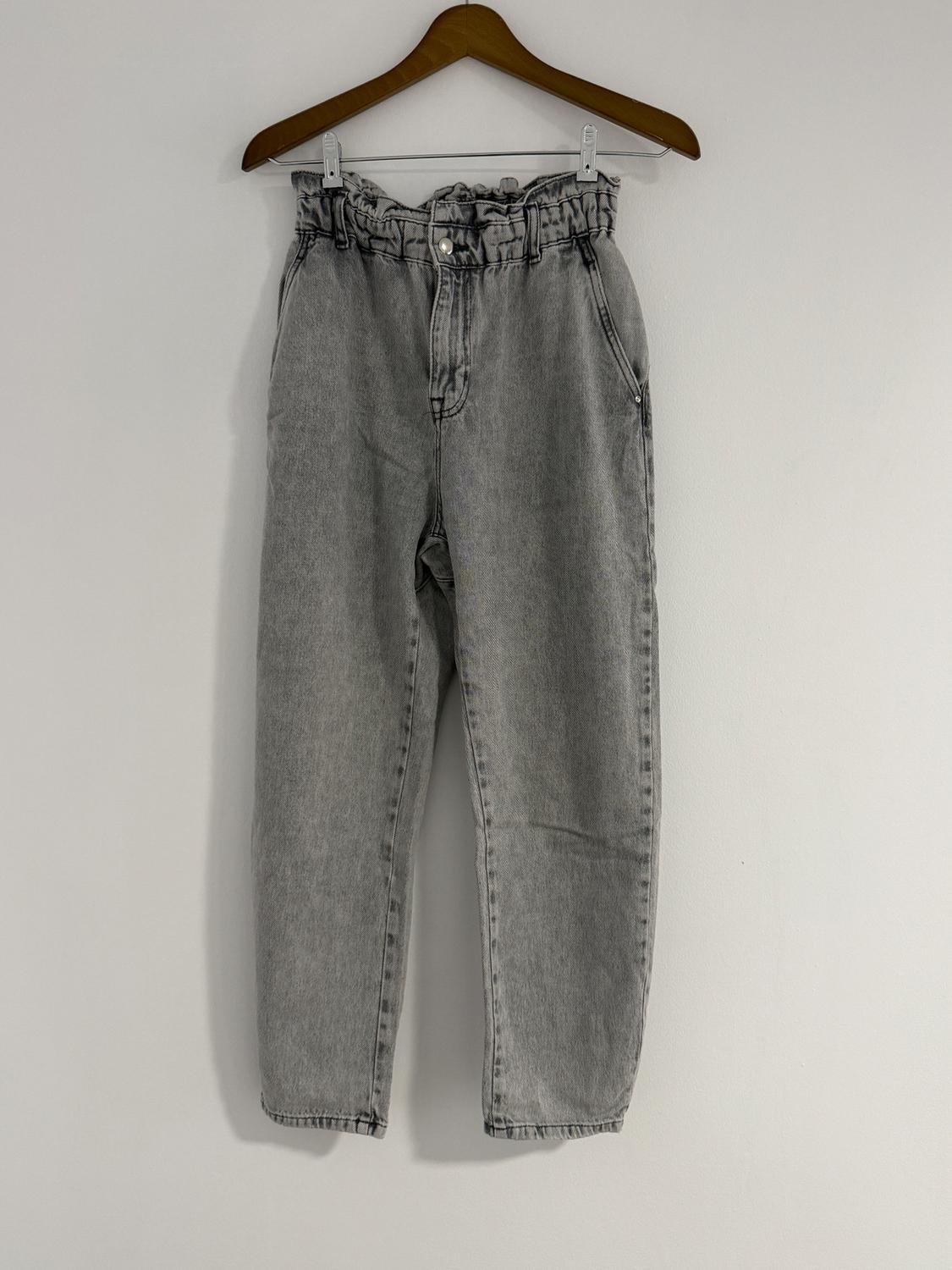 Light grey denim trousers with a ruched waist, hanging on a wooden hanger against a white background.
