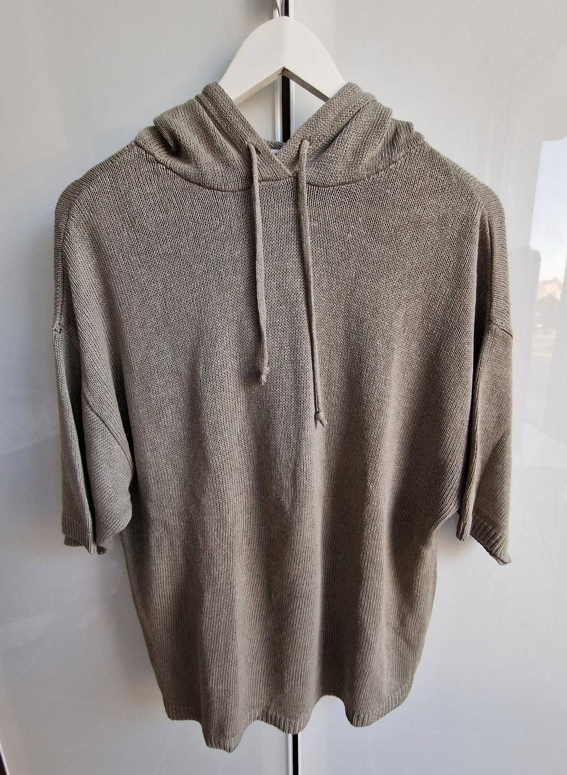 Light brown short-sleeved casual knitted hoodie, hanging on a white hanger against a light background.