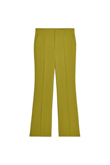 Front view of green pants with side pockets and center creases.