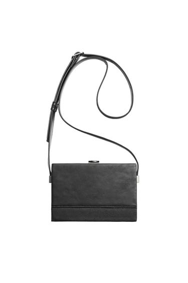 Front view of a rectangular black bag with adjustable strap and top closure.
