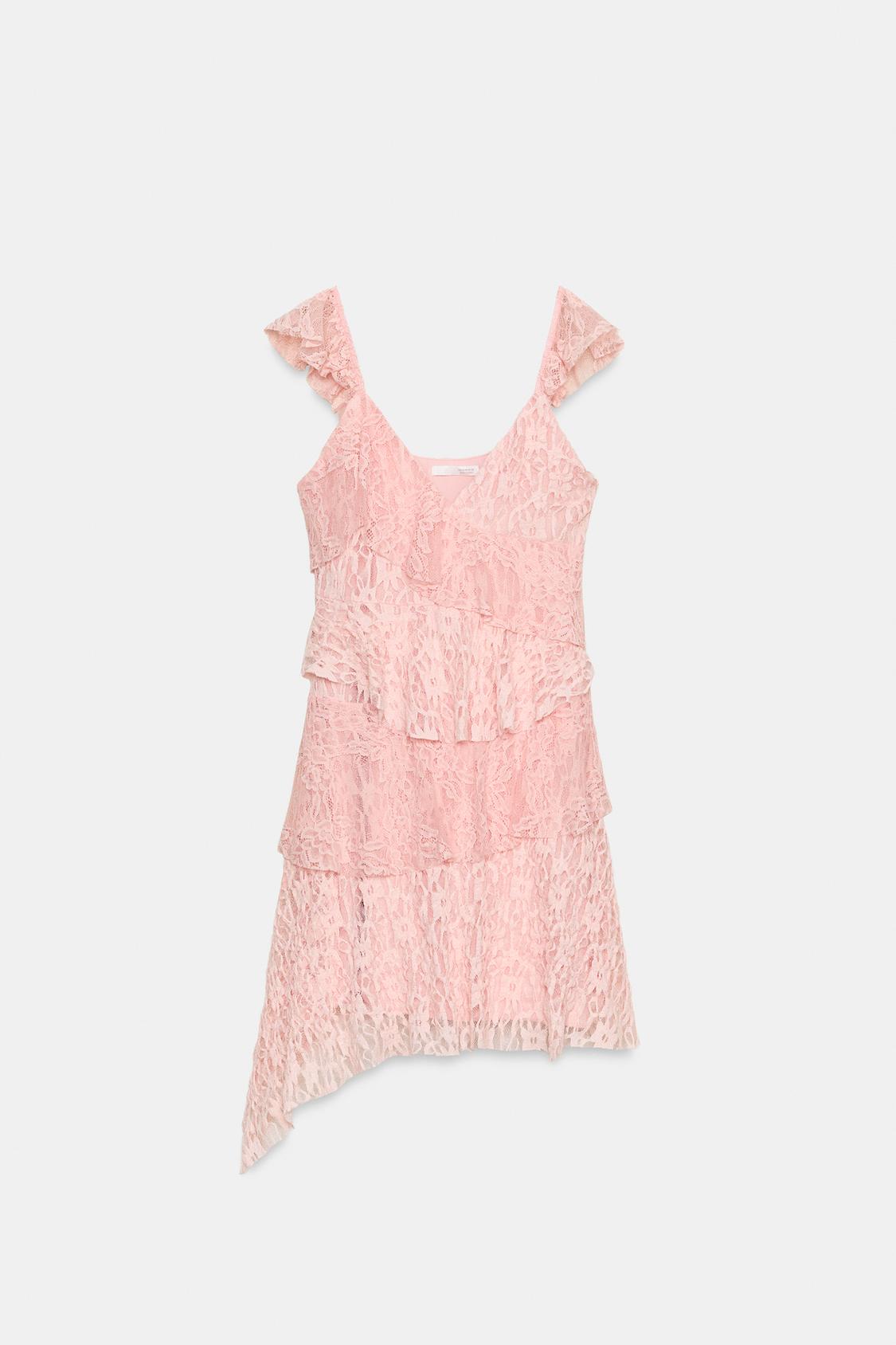 Front view of a pastel pink dress with ruffles, a V-neck, and straps. Asymmetric hem and matching inner lining.